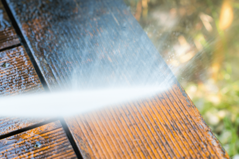 Closeup of water hitting wood with a pressure washer